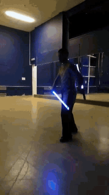 a person is holding a light saber in a room
