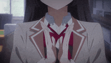 a girl in a school uniform has her hands folded in prayer