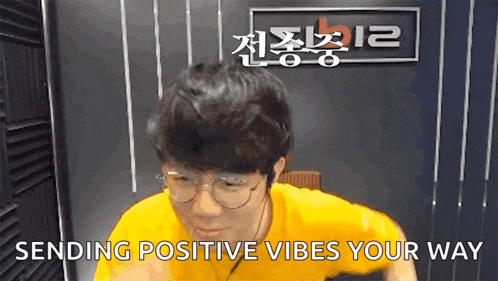a man wearing glasses and a yellow shirt is sending positive vibes your way .