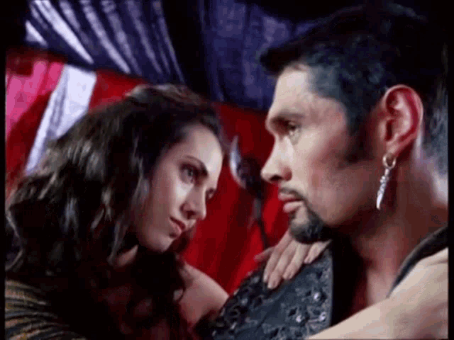 a man and woman are looking at each other in a room .