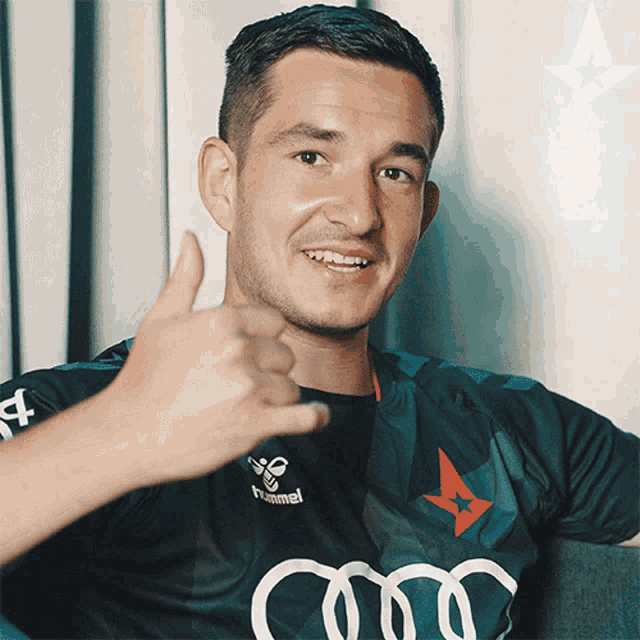 a man wearing a hummel shirt giving a thumbs up sign