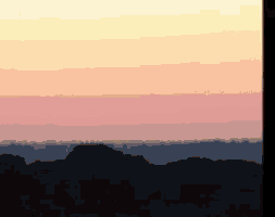 a sunset with trees in the foreground and a yellow and pink sky