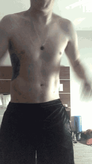 a shirtless man with a tattoo on his right side