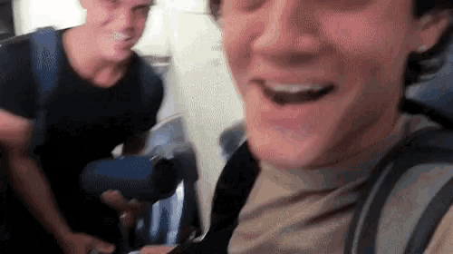 two men are standing next to each other and smiling