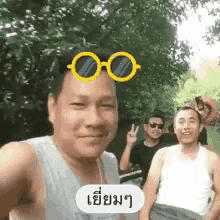 a man wearing sunglasses is taking a selfie with a group of other men .