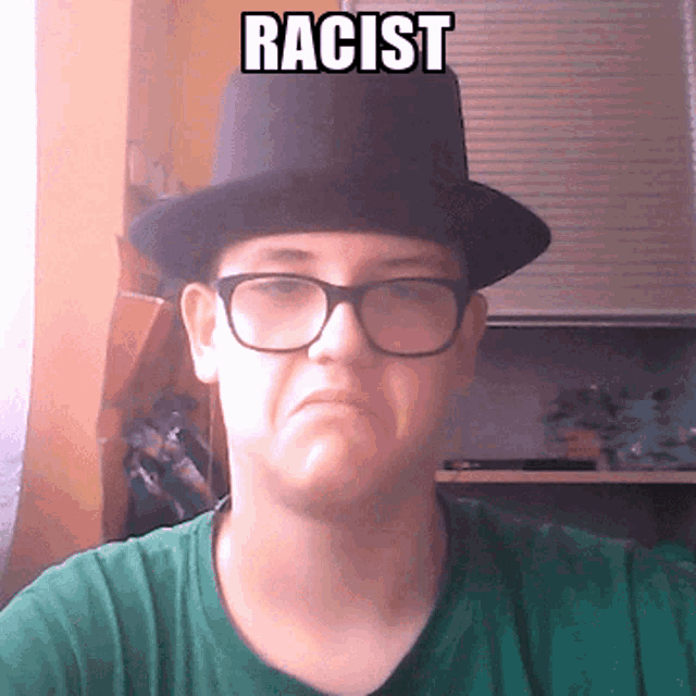 a man wearing glasses and a top hat has the word racist written on his face