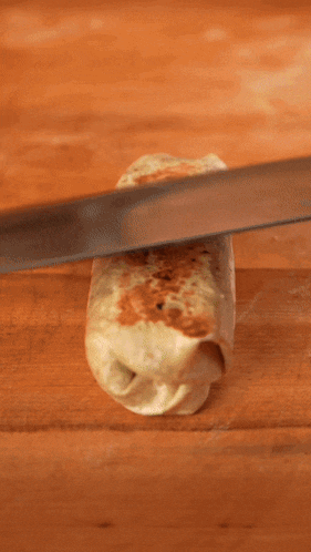 a person is cutting a burrito with a knife that says han