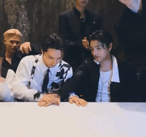 a group of men are sitting at a table .