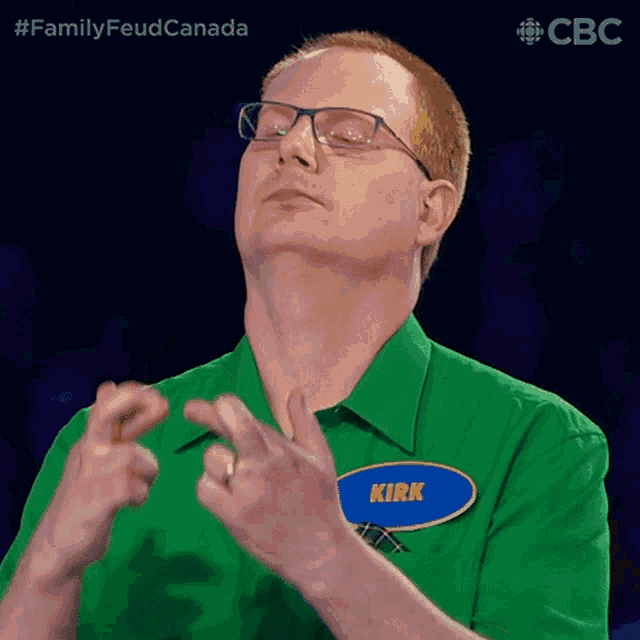 a man wearing glasses and a green shirt has a name tag that says kirk