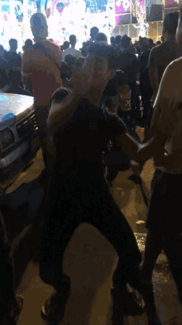 a man in a black shirt stands in a crowd of people