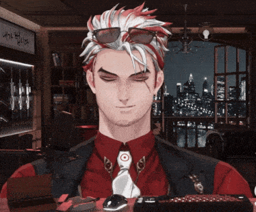 a man wearing sunglasses and a red shirt is sitting in front of a keyboard