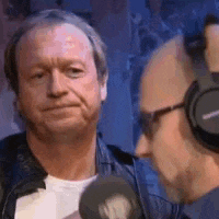a man is wearing headphones and talking into a microphone .