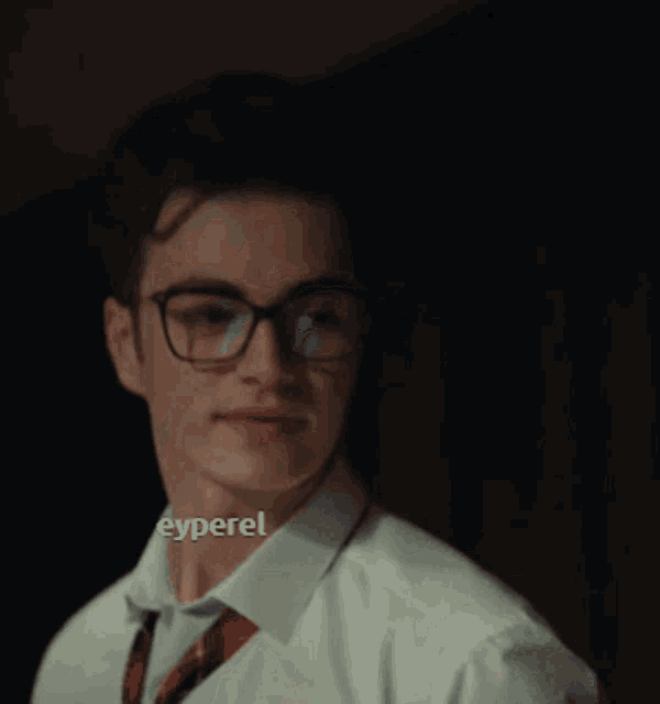 a man wearing glasses and a tie holds his finger to his mouth with the name eyperel below him