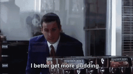 a man in a suit and tie is standing in front of a refrigerator and saying `` i better get more pudding . ''