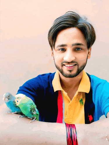 a man is holding a small bird on his arm