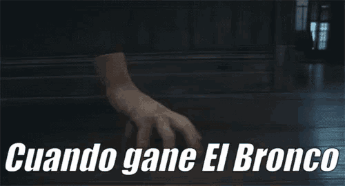 a close up of a person 's hand with the words cuando gane el bronco in white letters
