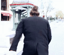 a woman in a black coat is walking down a street .