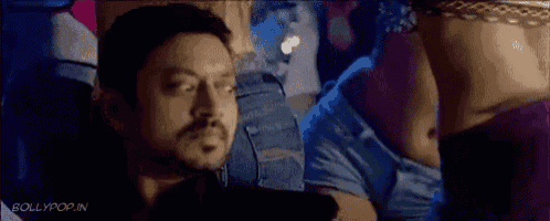 a man with a beard is looking at a woman 's stomach in a movie .