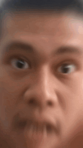 a close up of a man 's face with a surprised look on his face .