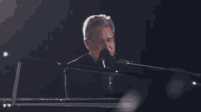 a man playing a piano in front of a roland piano