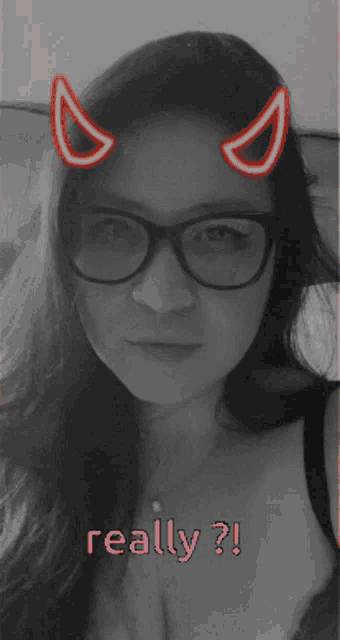 a black and white photo of a woman wearing glasses and devil horns