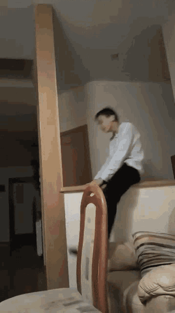 a boy is sitting on a chair in a room