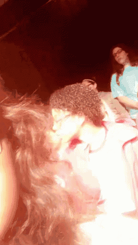 a woman with curly hair is standing in a dark room