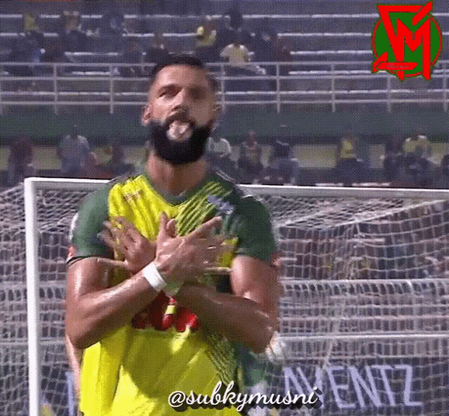 a man with a beard wearing a yellow and green jersey with the name subkymusni written on it