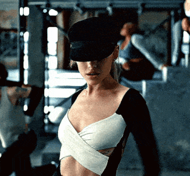 a woman wearing a black hat and a black and white crop top