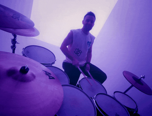 a man playing drums with a shirt that says ' aa ' on it