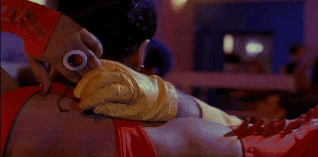 a bald man in a yellow shirt is being hugged by a woman