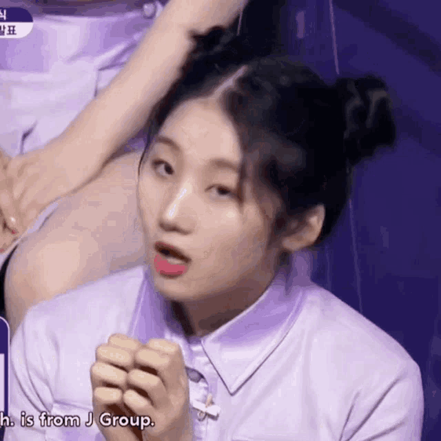 a girl in a purple shirt is making a funny face with the words " h is from j group " next to her