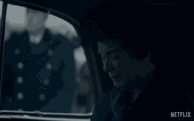 a woman is crying in a car with a netflix logo on the bottom