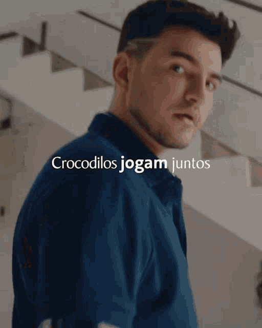 a man in a blue shirt with the words " crocodilos jogam juntos " above him