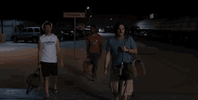 three men are walking down a street with the words it 's done written on the ground
