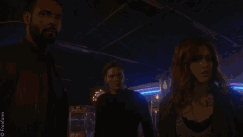 a man and a woman are standing in a dark room .
