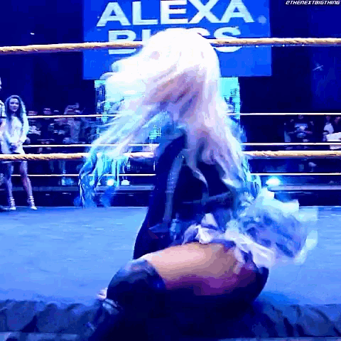 a woman in a wrestling ring with a alexa sign in the background