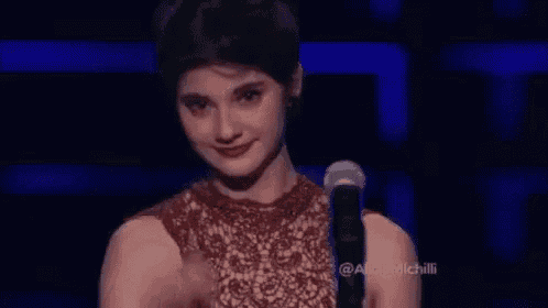 a woman is sitting in front of a microphone and crying .