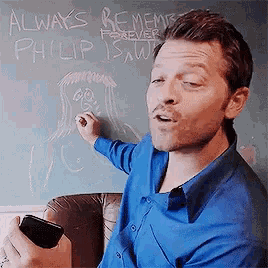 a man in a blue shirt is writing on a blackboard that says always remember philip