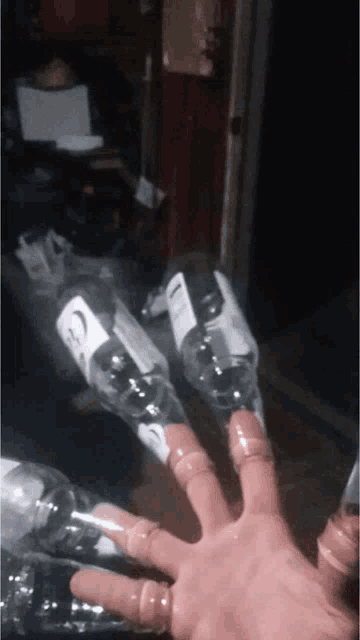 a person 's hand is holding a bottle of vodka with the letter c on the label