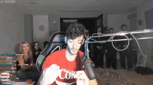 a man wearing a red coca cola shirt stands in front of a microphone in front of a crowd