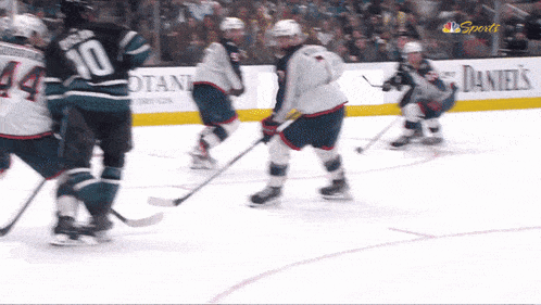 a hockey game is being played in front of a banner that says daniels