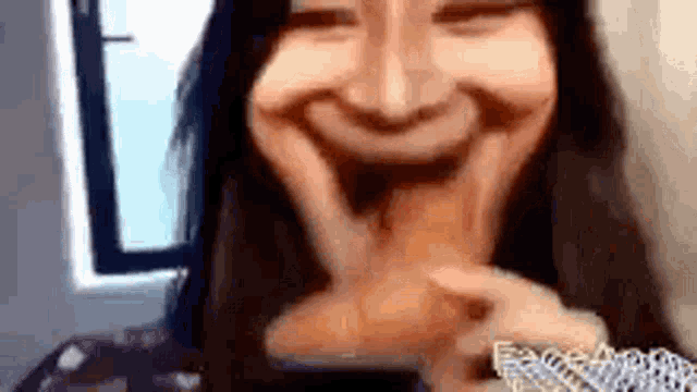 a woman is eating a croissant and making a funny face .
