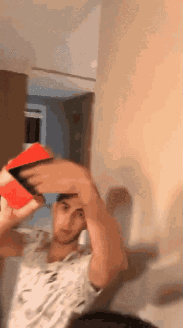 a man in a white shirt is holding a red box in his hands