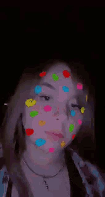 a girl with smiley faces on her face .