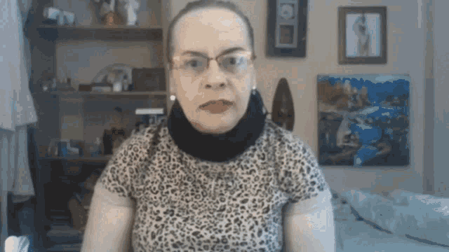 an older woman wearing glasses and a leopard print shirt