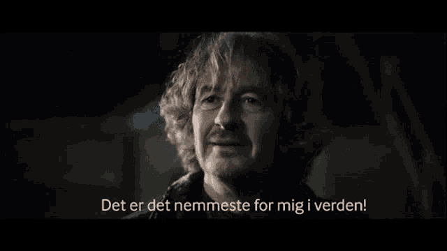 a man with curly hair and a beard is saying det er det nemmeste for mig i verden