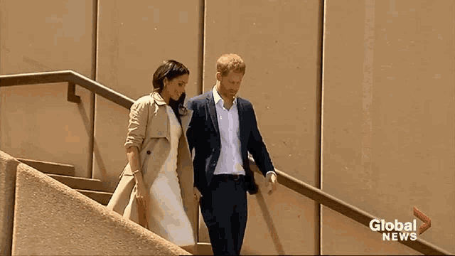 prince harry and meghan markle are walking down stairs in front of a global news sign