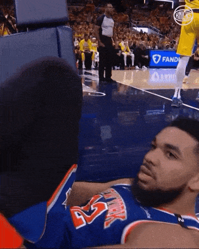 a basketball player laying on the floor wearing a jersey with the number 45