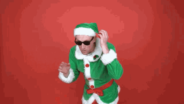 a man dressed as a santa claus is talking on a cell phone .